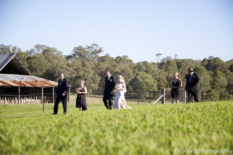 Wedding party walking through paddock - wedding photography sydney